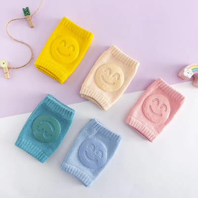 Five colorful Cuddle Crawl Knee Pads for babies displayed on a soft pastel background, designed for protection and comfort while crawling